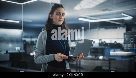 Portrait of a Happy Smiling Female, Using Laptop Computer, Looking at Camera and Smiling. Empowered Information Technology Specialist, Software Engineer or Developer Stock Photo