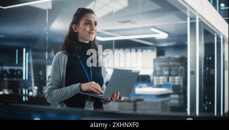 Portrait of a Beautiful Happy Female Using Laptop Computer, Looking Around the Office, Thinking and Solving Problems. Information Technology Specialist, Software Engineer or Developer Stock Photo