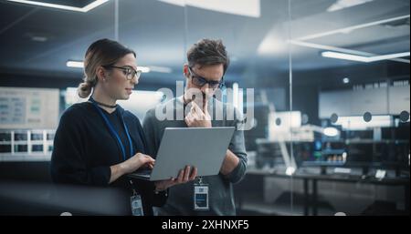 Multicultural Chief Technology Officer Talking to Software Developer, Discussing Neural Network Updates in High Tech Research and Development Facility. Professional Computer Specialists at Work Stock Photo