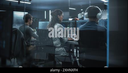 Group of Multicultural Men and Women Working in a Research Center, Collaborating and Discussing a Project, Using Computers to Write Advanced Software Code, Develop Artificial Intelligence Service Stock Photo