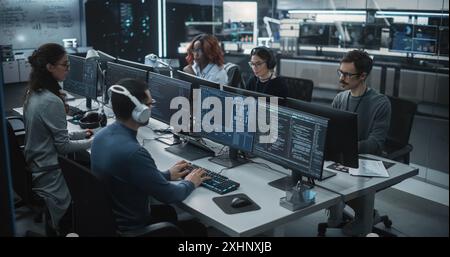 Team of Talented Young Professionals Working in a Technological Research and Development Agency. Computer Screens with Software Code, Customer Relationship Management Tool and Road Map User Interface Stock Photo