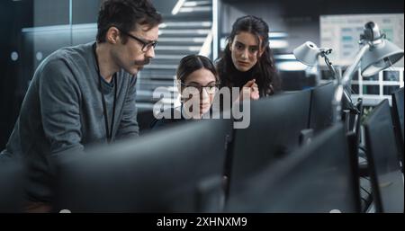 Team of Three Multiethnic Diverse Software Developers Talk, Discuss an AI Project. Stylish Young Specialists Work on Digital E-Commerce Startup Business Stock Photo