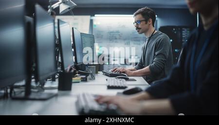 Portrait of a Thoughtful Engineer Working on Desktop Computer in a Technological Office Environment. Research and Development Department Writing Software Code for an Innovative Internet Project Stock Photo