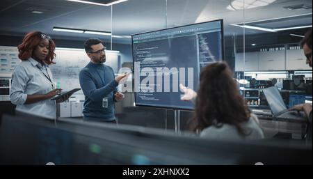 Team of Diverse Software Developers Having a Meeting in Order to Review the Code Done by Computer Engineering Department. Manager Making a Presentation for Project Managers at the Office Stock Photo