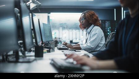 Portrait of a Thoughtful Black Female Engineer Working on Computer in a Technological Office Environment. Research and Development Department Writing Software Code for an Innovative Internet Project Stock Photo