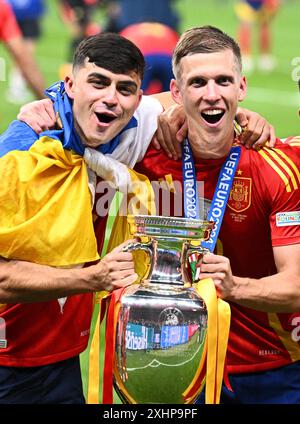 Berlin, Germany. 15th July, 2024. Soccer, UEFA Euro 2024, European Championship, Final, Spain - England, Olympiastadion Berlin, Spain's Pedri (l) and Dani Olmo celebrate with the trophy after winning the final. Credit: Tom Weller/dpa/Alamy Live News Stock Photo