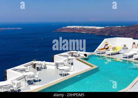 Greece, The Cyclades, Santorini island (Thera or Thira), village of Fira, terrace of a hotel with infinity pool overlooking the bay of Santorini and O Stock Photo