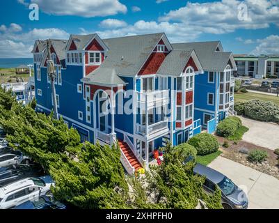 Victorian style luxury vacation rental property with bright blue and orange siding, multiple gables at the prime vacation rental property market OBX Stock Photo