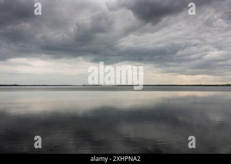 Dramatic stormy dark cloudy sky over sea Stock Photo