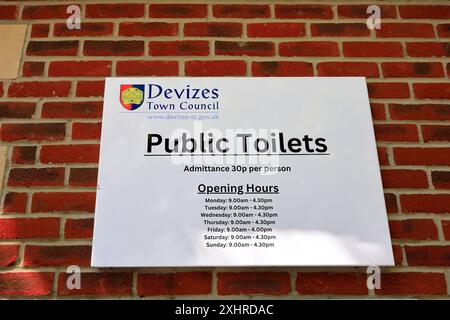 Devizes sign for Public Toilets - admittance 30p per person and opening hours on red brick wall, Devizes town centre. Taken July 2024. Summer. Stock Photo