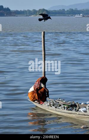 Rag picker collecting plastic bottle and other plastic materials in a boat from the bank of Brahmaputra River in Guwahati, Assam, India on Monday Stock Photo