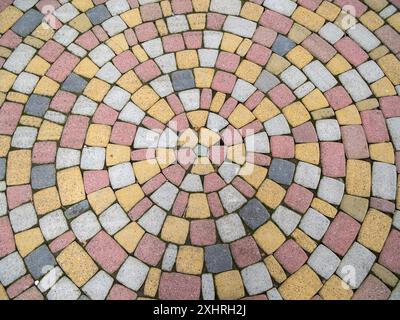 Paving stones made of multi-colored stones are laid out in the shape of circles Stock Photo