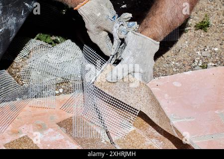 Thin flexible panel of artificial brick made of marble chips is reinforced with plastic mesh, which is cut with scissors during installation. Stock Photo