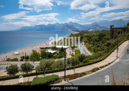 A scenic view of Konyaalti Beach in Antalya, Turkey with the Taurus Mountains in the background on a sunny day Stock Photo