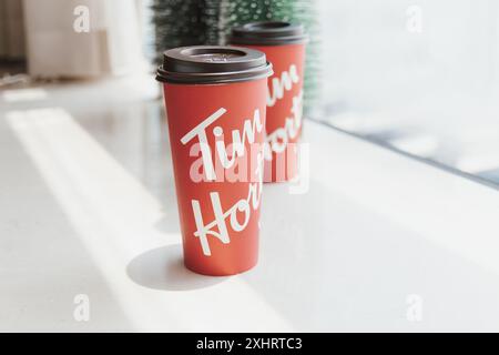 DUBAI, UAE - 9 AUGUST 2020: Tim Hortons takeaway red coffee cups with original logo on white cozy festive background Stock Photo