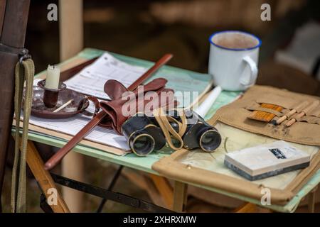 vintage wartime military equipment on a campaign planning table in a command tent. Stock Photo