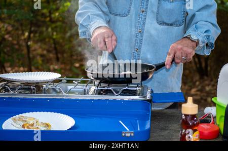 The campers in Akansas will soon enjoy an egg breakfast cooked in the great outdoors. Bokeh. Stock Photo
