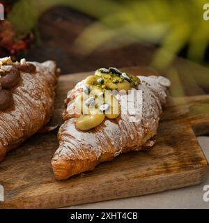 Freshly baked gourmet pistachio croissants on a wodden background. Coffee shop lifestyle. Stock Photo