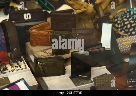 Astorga, Spain - June 3, 2023: A variety of leather wallets and belts are displayed on a shelf in a shop window in Astorga, Spain. Stock Photo