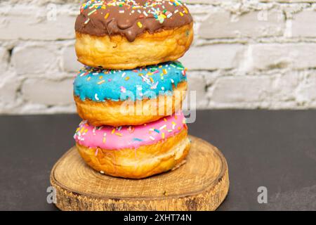 Delicious dessert. Pink, blue and chocolate donuts with multicolored sprinkles. Stock Photo