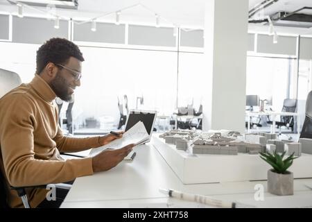 Dedicated man architect overseeing real estate projects in his office Stock Photo