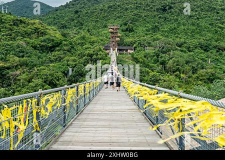 A long suspended wooden bridge in the forest park YaNoDa, A national park in the center of Hainan Island, China. Stock Photo