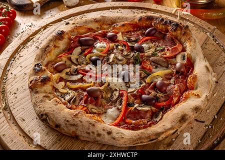 Pizza Quattro stagioni served on wooden cutting board Stock Photo