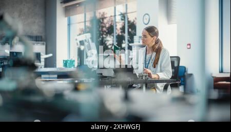 Portrait of Professional Female Scientist Working in Industrial Lab Using Laptop Computer. Successful Engineer Checking and Monitoring Production Quality, Analysing Data Using Technology Stock Photo