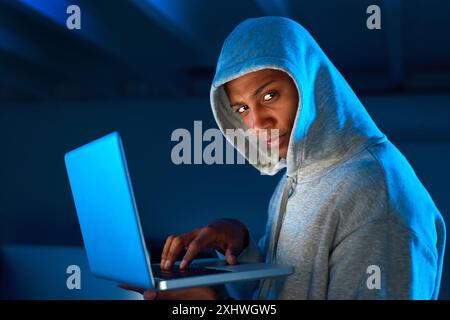 Portrait, black man or hacker on laptop in night for cybercrime, malware or stealing online data. Programmer, serious and software update for hacking Stock Photo