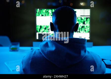 Back, person or hacker with laptop for cybercrime, malware or phishing for stealing online data. Programmer, night or typing software update on Stock Photo