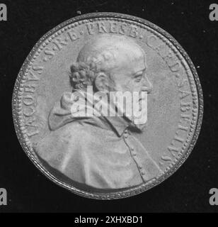 A small circular item of uncertain purpose, possibly a medal, seal, or coin, displaying engraved motifs, inscriptions, and raised reliefs for functional or symbolic use. Stock Photo