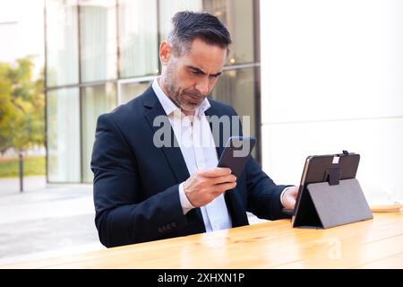Businessman using an app on his smartphone and standing Stock Photo