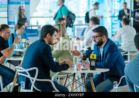 Moscow - April 10,2024: Professionals networking and engaging in discussions at business event Open Innovations Conference in Skolkovo Technopark at modern hall Stock Photo