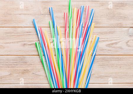 many multi-colored plastic tubes for cocktail on Colored background, top view. Stock Photo