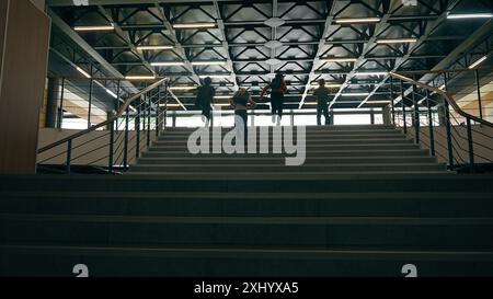 Back view fast unrecognizable schoolboys schoolgirls together running children run on stairs little classmates pupils Caucasian African kids boys Stock Photo