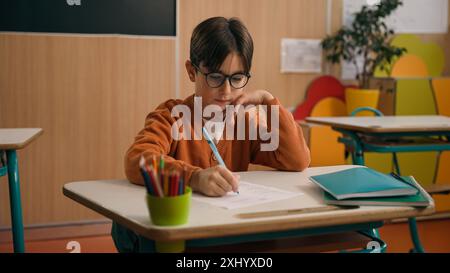 Back to school elementary primary education studying Caucasian boy little son guy schoolboy kid child pupil student schoolboy at class lesson study Stock Photo