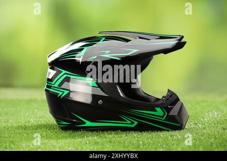 Modern motorcycle helmet with visor on green grass Stock Photo