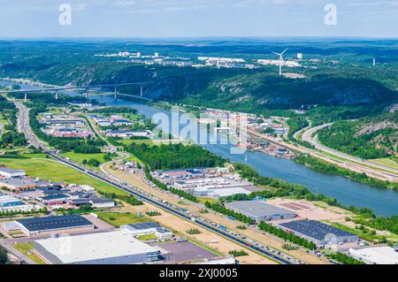 An aerial view of a busy motorway running through an industrial area in Hisingen, Gothenburg, Sweden. The highway is flanked by rows of warehouses and Stock Photo