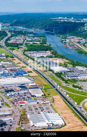 An aerial view of a busy motorway running through an industrial area in Hisingen, Gothenburg, Sweden. The highway is flanked by rows of warehouses and Stock Photo