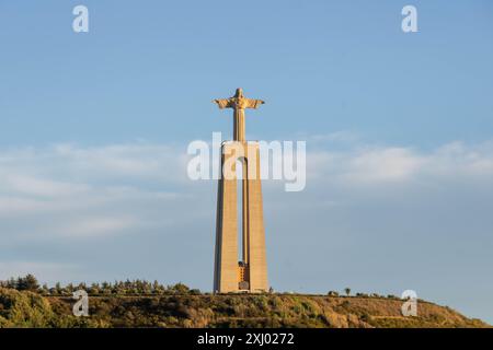 The Sanctuary of Christ the King (Portuguese: Santuário de Cristo Rei) at sunset as viewed from Tagus River, Lisbon Stock Photo