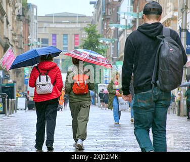 Glasgow, Scotland, UK. 16th July, 2024: UK Weather: Rain saw tourists and locals in the city centre dive for their umbrellas in the showers with a forecast for more. Credit Gerard Ferry/Alamy Live News Stock Photo