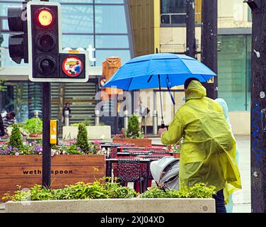 Glasgow, Scotland, UK. 16th July, 2024: UK Weather: Rain saw tourists and locals in the city centre dive for their umbrellas in the showers with a forecast for more. Credit Gerard Ferry/Alamy Live News Stock Photo