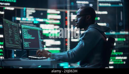 Shot of a Black Male Programmer Working in a Monitoring Control Room, Surrounded by Big Screens Displaying Lines of Programming Language Code. Portrait of a Man Creating a Software and Coding Stock Photo