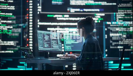 Female Developer Thinking and Typing on Computer, Surrounded by Big Screens Showing Coding Language. Professional Programmer Working in a Modern Office, Running Coding Tests. Futuristic Programming Stock Photo
