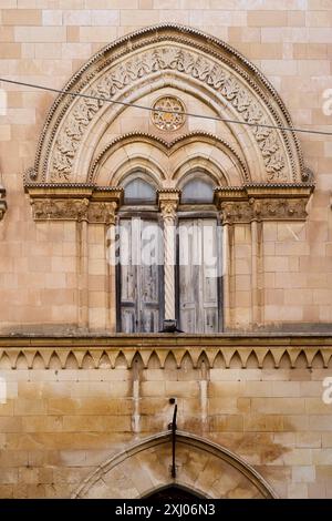 Historic Stone Building With Arched Wooden Door and Windows Stock Photo