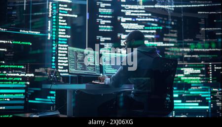 Black Male Developer Thinking and Typing on Computer, Surrounded by Big Screens Showing Coding Prompts. Professional Programmer Creating Software, Running Coding Tests. Futuristic Programming Concept Stock Photo