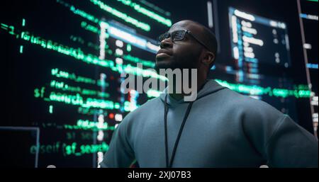 Portrait of Worried Professional Programmer Fixing a Bug, Dealing with Crashing System. Young Black Man Looking at Big Digital Screens Glitching While Displaying Code Lines and Thinking of Solutions Stock Photo