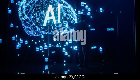 Back View of a Woman Holding Laptop Computer, Standing in Front of Big Digital Screen with AI Neural Network 3D Visualization. Professional Data Scientists Activating Artificial Inteligence System Stock Photo