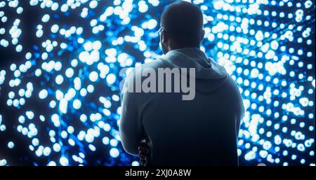 Black Young Man Looking at Big Screen with Neural Network Visualisation In 3D. Professional Computer Data Science Engineer Working in System Control and Monitoring Telecommunications Office Stock Photo