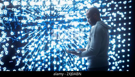 Portrait of Young Black Man Working on Laptop, Looking at Big Digital Screen Displaying Neural Network Visualisation in 3D. Professional Data Specialist Analysing User Information Concept. Stock Photo